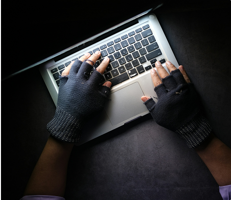Manos con guantes frente a notebook